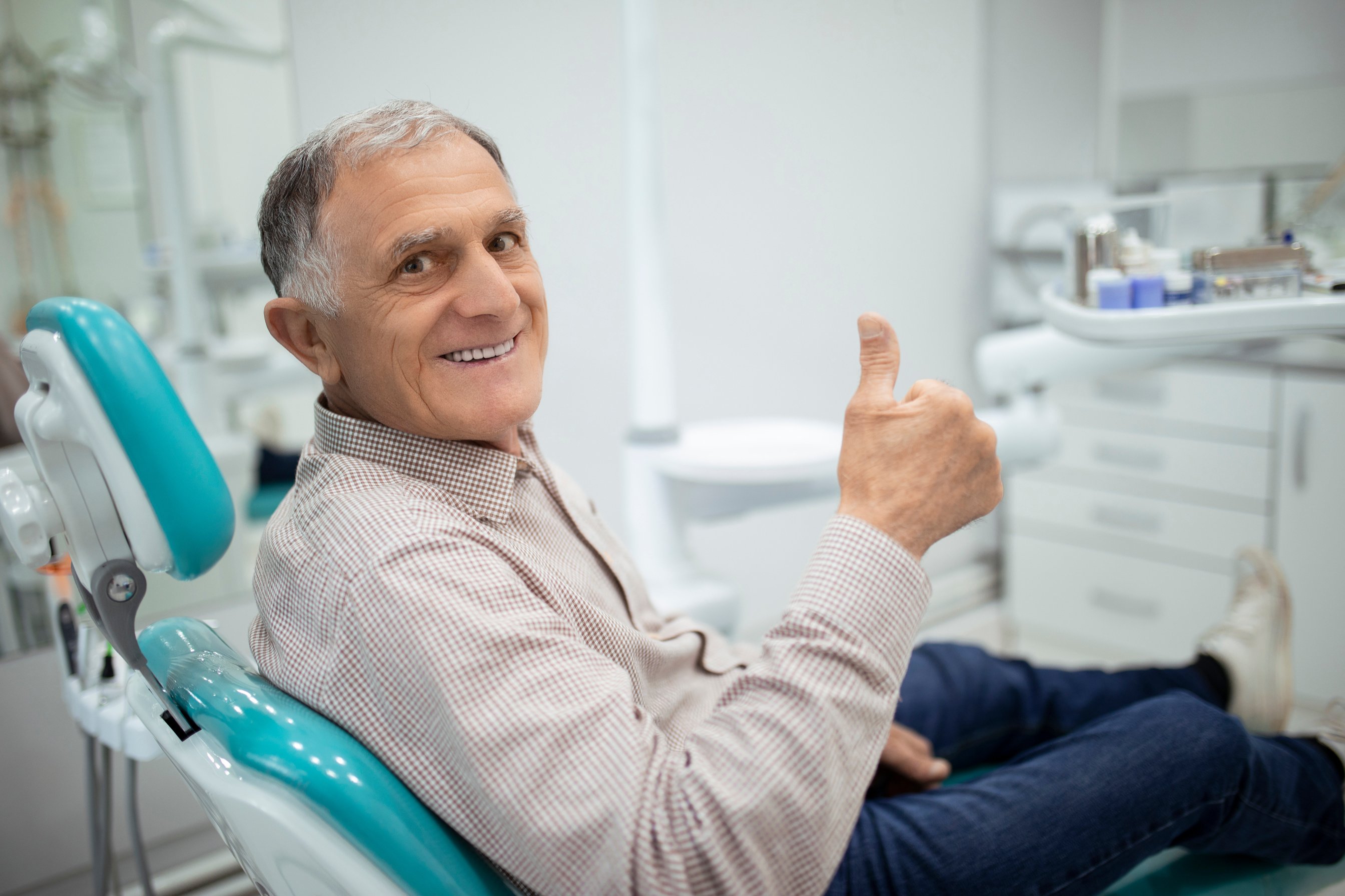 Old senior man sitting in a dental chair